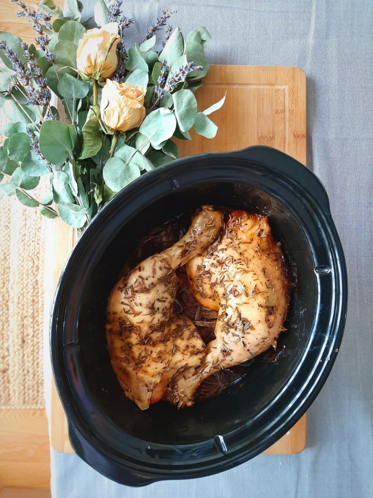 TOp view of Rosemary chicken quarters in crockpot insert
