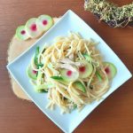 Green pasta with shredded chicken decorated with watermelon radish top view